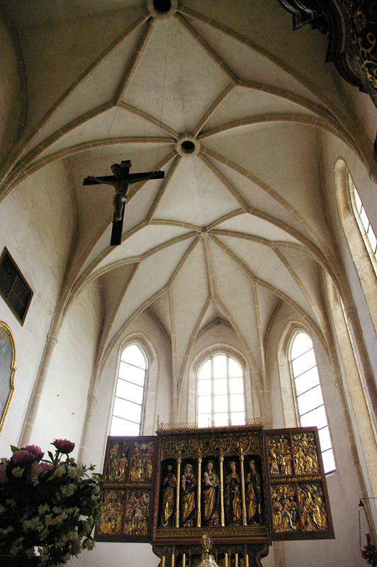 Hochaltar mit romanischen Holzkruzifix im Vordergrund